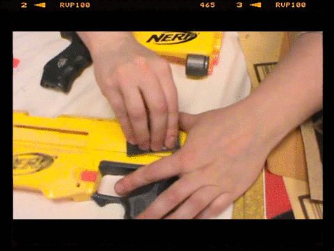 Sanding a Nerf blaster shell in a circular motion with a small piece of sandpaper